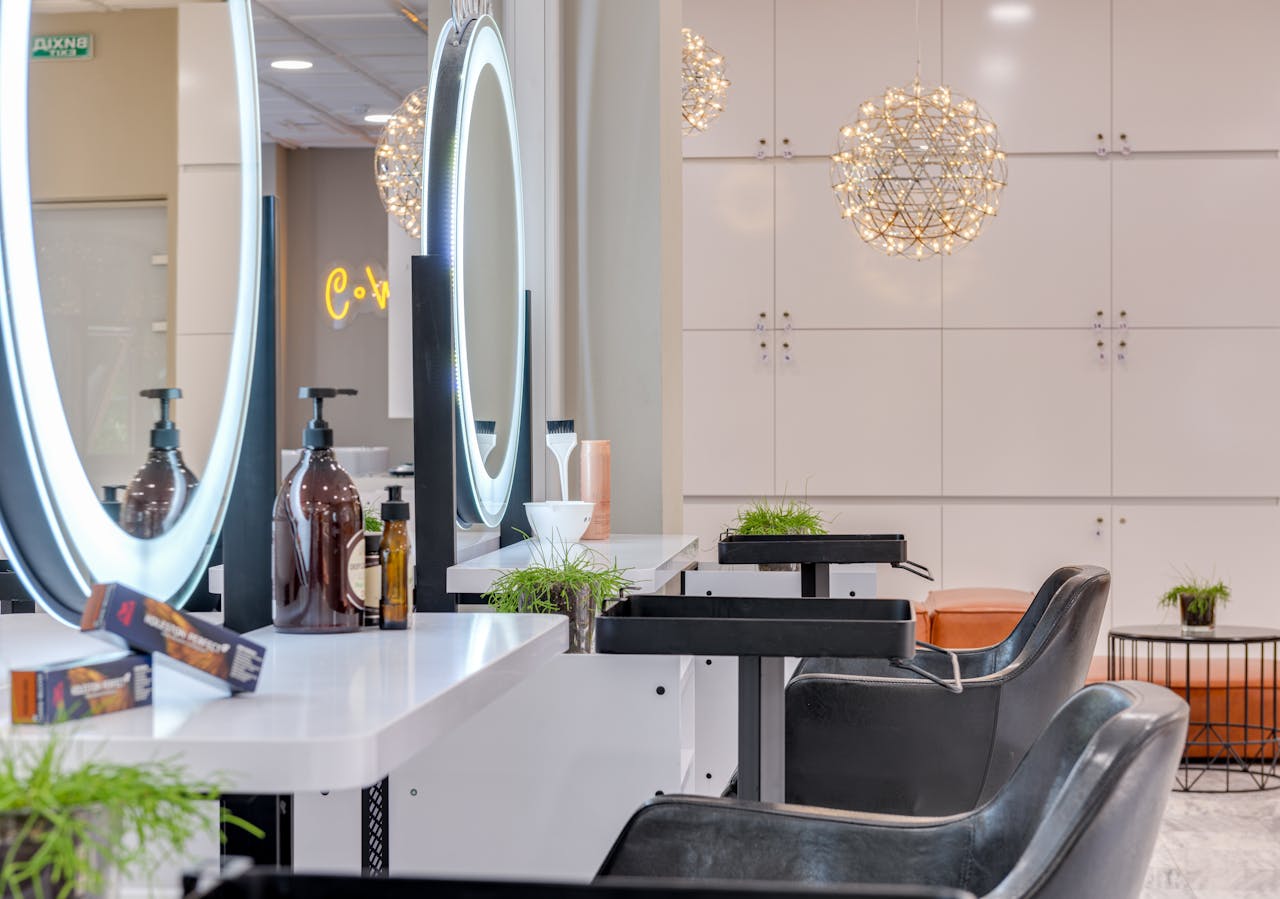 Elegant modern beauty salon with comfortable chairs and illuminated LED mirrors for a stylish experience.